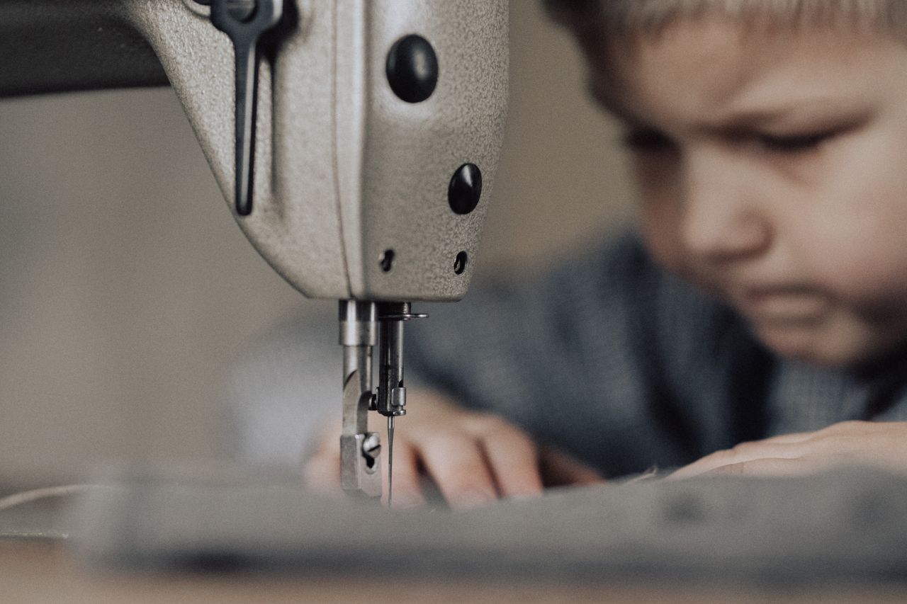 Kind naait aandachtig aan een naaimachine